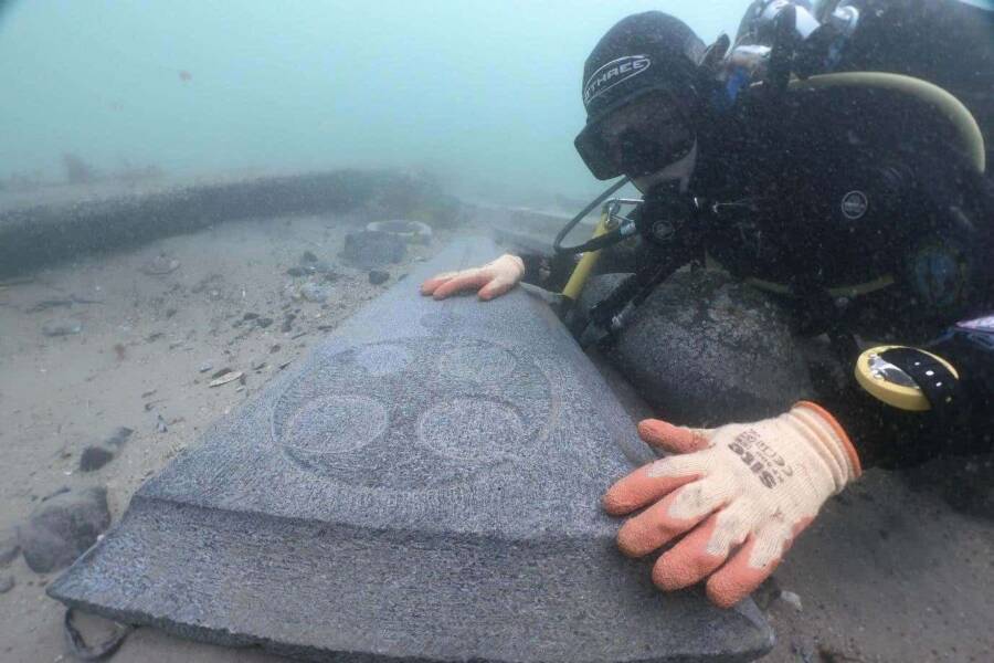 England’s Oldest Known Shipwreck Found, With A Morbid Cargo 2 A diver inspects one of the Purbeck marble gravestones discovered amid the wreck.