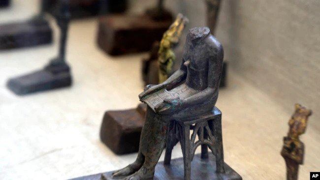 A headless bronze statue of Imhotep, the chief architect of Pharaoh Djoser who oversaw the building of the step pyramid, is on display at a makeshift exhibit at the feet of the Step Pyramid of Djoser in Saqqara,near Cairo, Egypt, May 30, 2022.