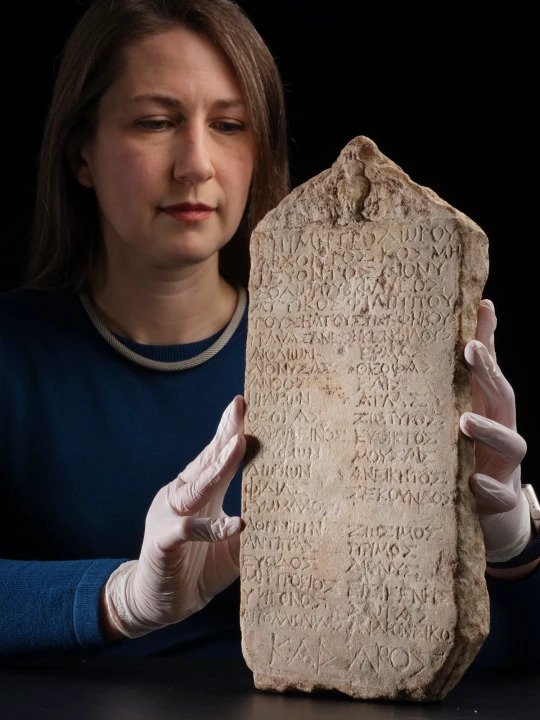 Dr Margaret Maitland with the ancient stone